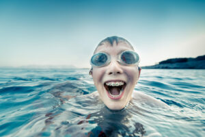 A little boy with braces still enjoying swimming